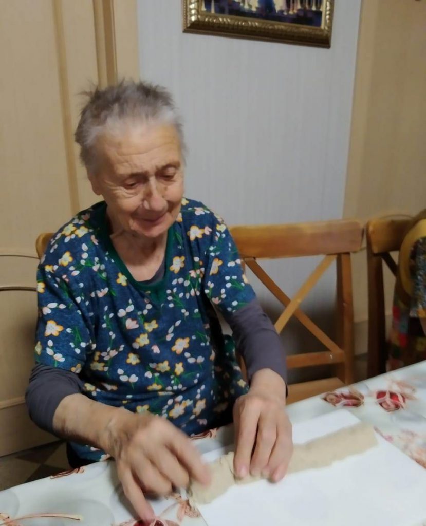 Пожилые постояльцы дома престарелых готовят пирожки из песка для лепки